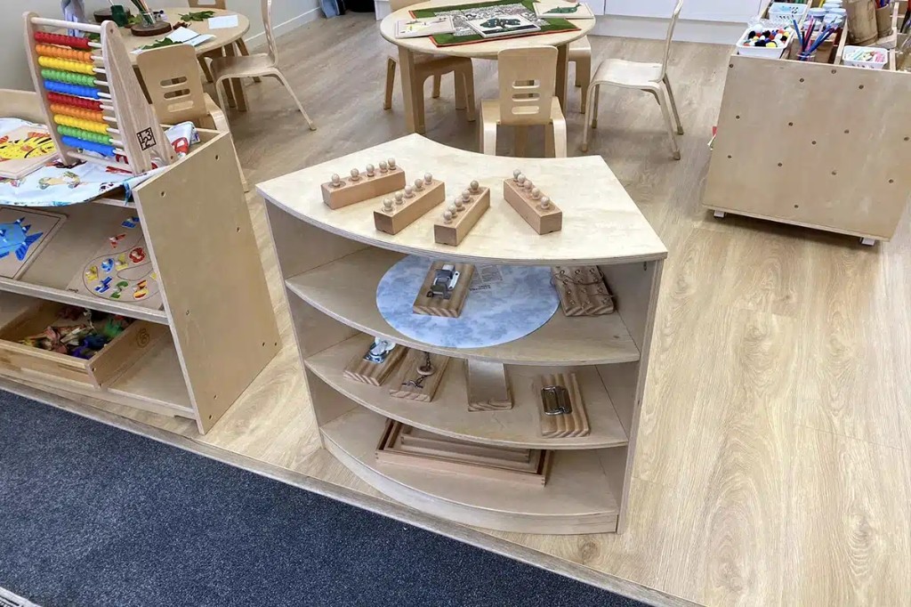 Montessori sensorial and practical life shelves with knobbed cylinders and activity boards