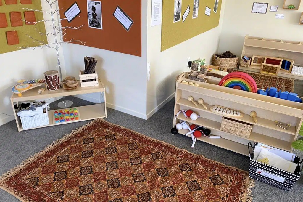 Music and movement shelf with instruments, rainbow stacker, and geometric solids