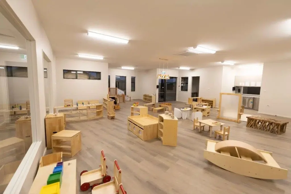 Centre fit-out in progress — wide open-plan classroom with light wood furniture, zoned activity areas, and bright interior