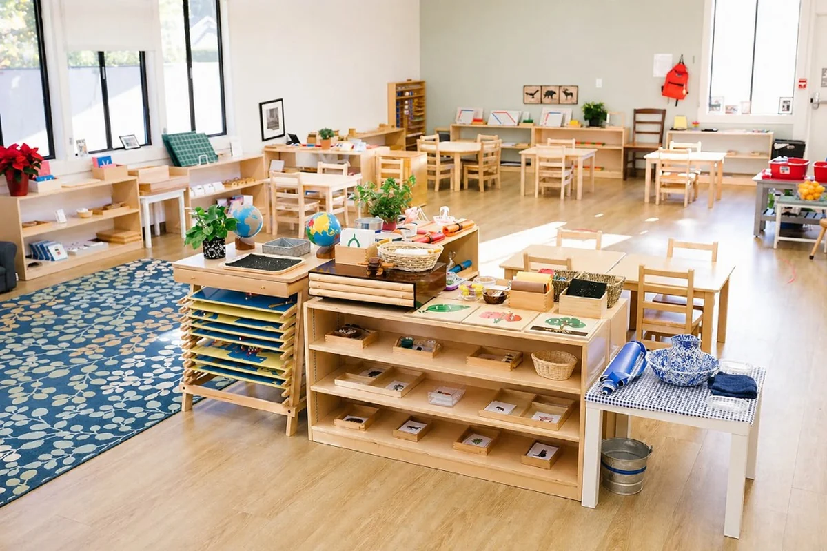Low Montessori-style material shelves with activity trays, learning materials, and child-sized tables in a bright NZ early learning classroom